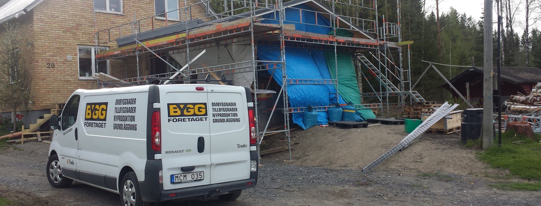 På bilden ser man ett garage som nästan är färdigt och Byggföretaget Umeå ABs firmabil.